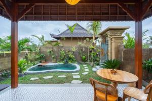une cour avec une piscine, une table et une terrasse dans l'établissement Sawah Sebatu Villa, à Ubud