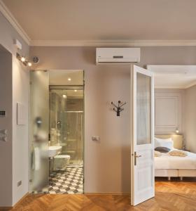 uma casa de banho com um chuveiro e um quarto com uma cama em URBANAUTS BELETAGES Sonata em Trieste