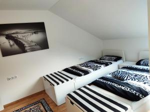 two beds in a room with a picture on the wall at Ferienwohnung "Zur alten Schreinerei" Gundelfingen - Donau in Gundelfingen an der Donau