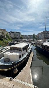 Ein weißes Boot liegt an einem Dock. in der Unterkunft LOFT SUR L'EAU AVEC BALNEO in Cergy