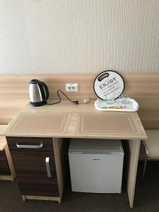 drewnianym biurkiem z dzbankiem do herbaty. w obiekcie Hostel Iskra w Lwowie