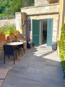 een patio met een tafel en een groene deur bij Estate Riomaggiore in Riomaggiore