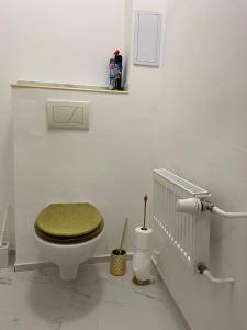 a white bathroom with a toilet with a green seat at Apartmán v historickém centru Ostravy in Moravská Ostrava +39 photos