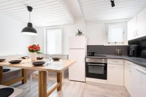 a kitchen with a wooden table and a white refrigerator at Top floor apartment next to Marienplatz in Munich