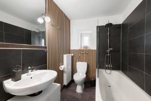 a bathroom with a sink and a toilet and a bath tub at Top floor apartment next to Marienplatz in Munich +14 photos