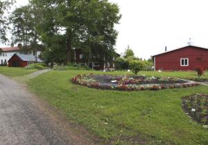 een cirkel van bloemen in een veld naast een rode schuur bij Nordvik Bed & Breakfast in Nordvik