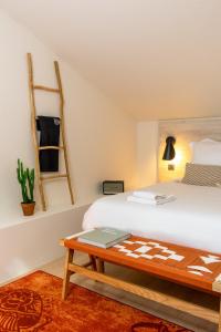 a bedroom with a bed and a table with a laptop on it at Hôtel AKENA Biarritz - Grande plage in Biarritz