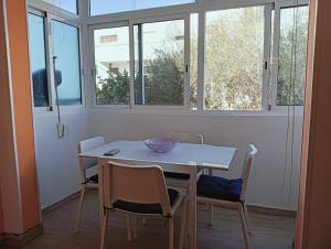 a white table and chairs in a room with windows at FUERTE CAMPILLOS in Costa de Antigua