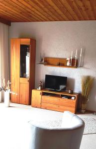 een woonkamer met een tv op een houten entertainmentcentrum bij Haus Christof 