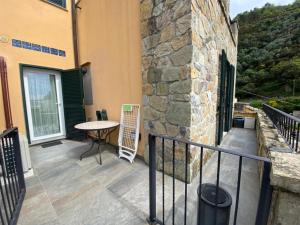 balkon ze stołem i kamienną ścianą w obiekcie Estate Riomaggiore w mieście Riomaggiore