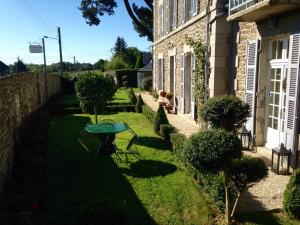 a garden with a table in the grass next to a building at La Gougeonnais in La Richardais