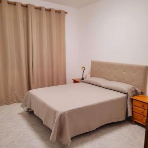 um quarto com uma cama e uma cómoda e cortinas em Casa Pancho Lanzarote em Playa Honda