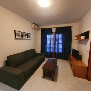 Casa Pancho Lanzarote في بلايا هوندا: غرفة معيشة مع أريكة خضراء وطاولة
