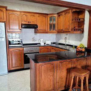 a kitchen with wooden cabinets and a counter top at Casa Pancho Lanzarote in Playa Honda