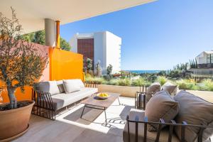 a patio with a couch and chairs and a table at Leiro Residences in Fuengirola