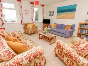 a living room with two couches and a tv at Seaview in Coverack