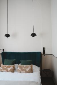 a bedroom with a bed with three lights above it at Hôtel des Beaux Arts in Paris