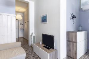 Una sala de estar con televisión y un sofá. en Casa di Elena Marina di Carrara, en Marina di Carrara