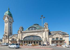 un grande edificio con una torre dell'orologio su una strada di Bienvenu chez Zazou a Limoges