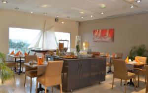 a restaurant with a sail boat on the wall at Hotel Restaurant Lesage in Sarzeau