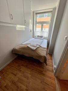 um pequeno quarto com uma cama e uma janela em Central 1BR Apartment em Narvik