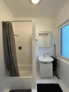 La salle de bains blanche est pourvue d'une douche et d'un lavabo. dans l'établissement Charmante Wohnungen direkt in der Stadtmitte, à Andernach