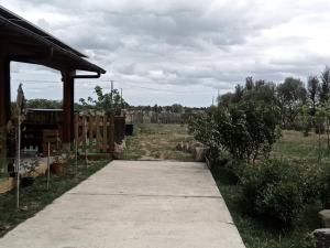 Podere Kiri Dome Experience في Decimomannu: ممشى يؤدي لحقل به سياج