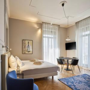um quarto com uma cama, uma mesa e cadeiras em URBANAUTS BELETAGES Sonata em Trieste