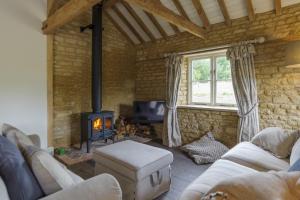a living room with a couch and a stove at Pea Cottage in Stamford