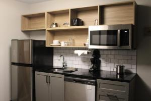 a kitchen with a stainless steel refrigerator and a microwave at Candlewood Suites - Nashville South, an IHG Hotel in Nashville