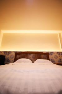 a bedroom with a large bed with white sheets at BK Hotel in Mae Sariang