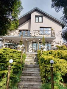a house with stairs in front of it at PENSJONAT KAPRYS in Jesionka