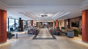 Hôtel Alpen Lodge في لا روزيير: لوبي فندق فيه كراسي وطاولات