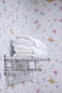 un montón de toallas en un estante en un baño en BK Hotel, en Mae Sariang
