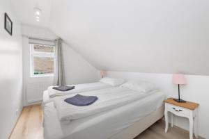 a white bedroom with a bed and a window at Guesthouse Rauðafell in Holt