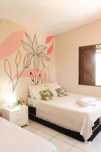 1 dormitorio con 2 camas y un mural de flores en la pared en Nirvana Pipa, en Pipa
