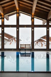 Piscina en una habitación con ventanas en MGM Hôtels & Résidences - Résidence Alpen Lodge, en La Rosière