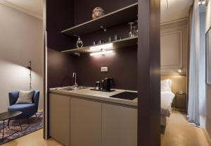 uma cozinha com um lavatório e uma cama num quarto em URBANAUTS BELETAGES Sonata em Trieste