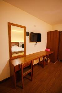a dressing table with a mirror and a bed at BK Hotel in Mae Sariang