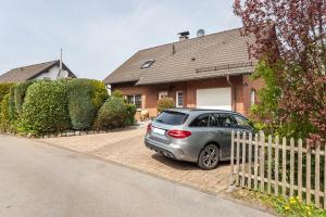 ein silbernes Auto, das vor einem Haus parkt in der Unterkunft Ferienwohnung Am Wald in Herscheid