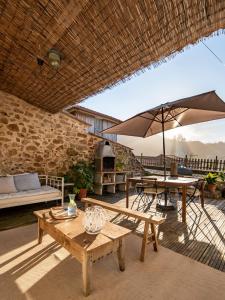 a patio with a table and an umbrella at Doni Beach House in A Coruña