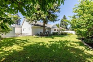 a white house with a large yard with trees at Big Family Getaway- Theater Room- BBQ- Play Room- Fire Pit in Coeur d'Alene
