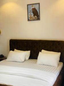uma cama com duas almofadas e uma fotografia na parede em BLUE AO HOTEL AND SUITES em Lagos