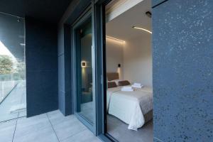 a bedroom with a bed and a sliding glass door at HEVENIA POGORZELICA - Apartament 4 z bezpośrednim widokiem na morze in Pogorzelica