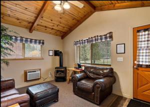 a living room with leather chairs and a desk at Cabin 3 at Southfork Lodge- Sleeps 2 in Lowman