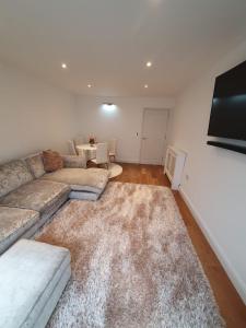 - un salon avec un canapé et une télévision dans l'établissement Broxbourne apartment (2 bed), à Broxbourne