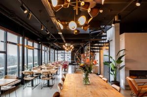 een eetkamer met tafels, stoelen en ramen bij Cityden Zuidas in Amstelveen