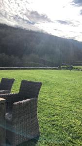 two wicker chairs sitting in a field of grass at Pension Casa Simon in Tríacastela