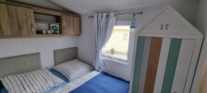 a small bedroom with a bed and a window at Traumlage Nr 67 Traumblick direkt am Wattenmeer erste Reihe unendliche Weite, eingebettet in der Natur in Westerland