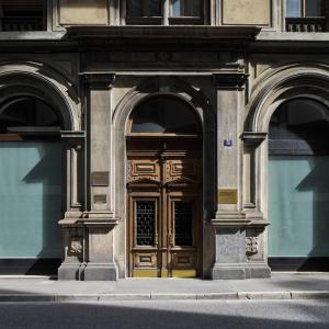 um edifício com uma porta de madeira com dois arcos em URBANAUTS BELETAGES Sonata em Trieste